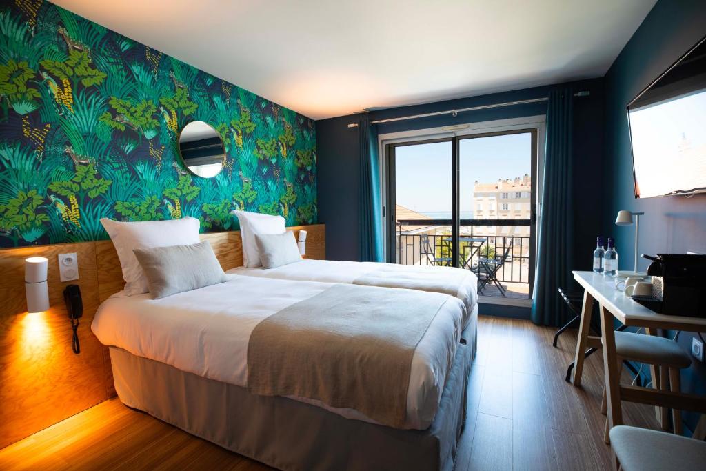 a bedroom with a large bed and a balcony at T Boutique Hotel in Arcachon