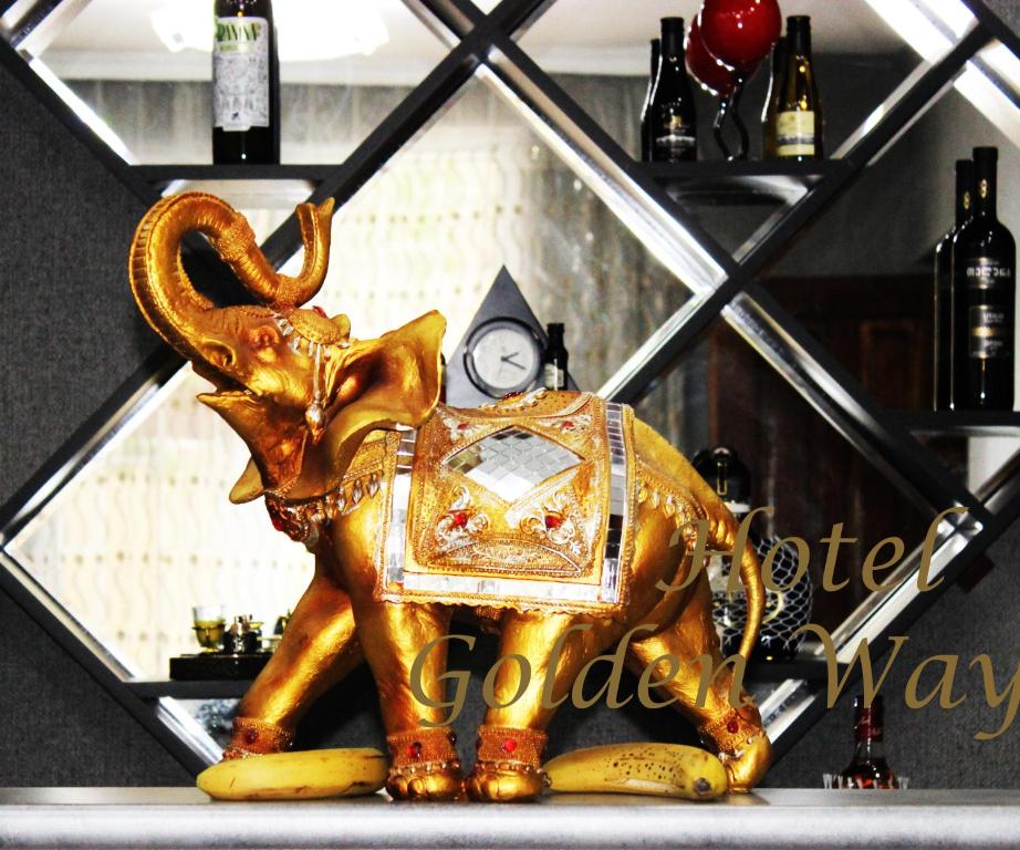 einen goldenen Elefanten und eine Uhr im Regal in der Unterkunft Golden Way in Tbilisi City