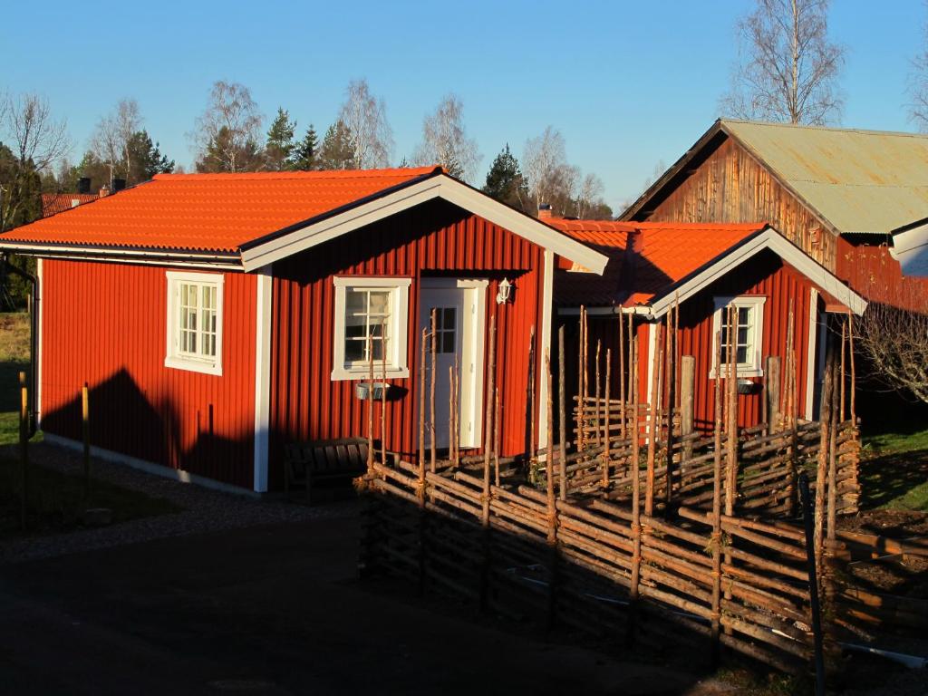 ムーラにあるUtmelandsvägen 26の塀の前のオレンジ色の家
