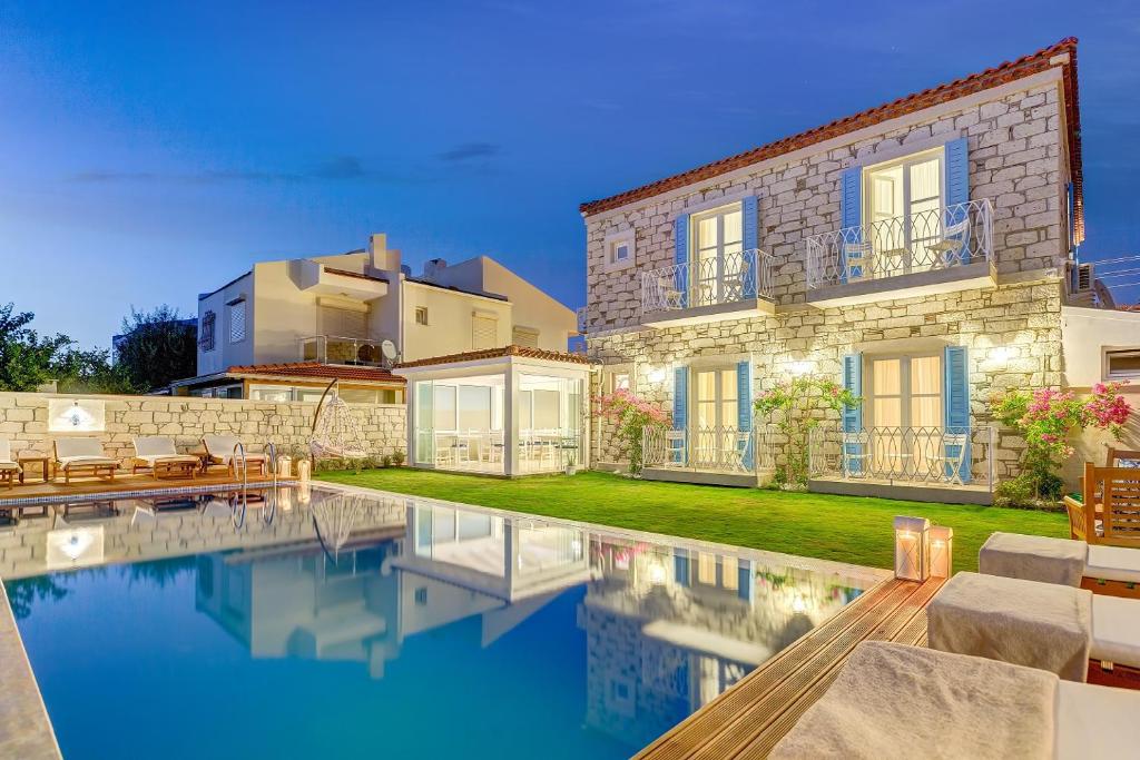 a house with a swimming pool in front of it at ALAÇATI VİLLAPERİ BUTiK OTEL in Alacati