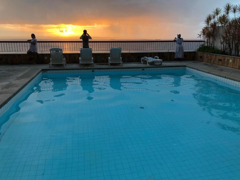 einen Pool mit Sonnenuntergang im Hintergrund in der Unterkunft Flat Privativo Sol Victoria Marina in Salvador