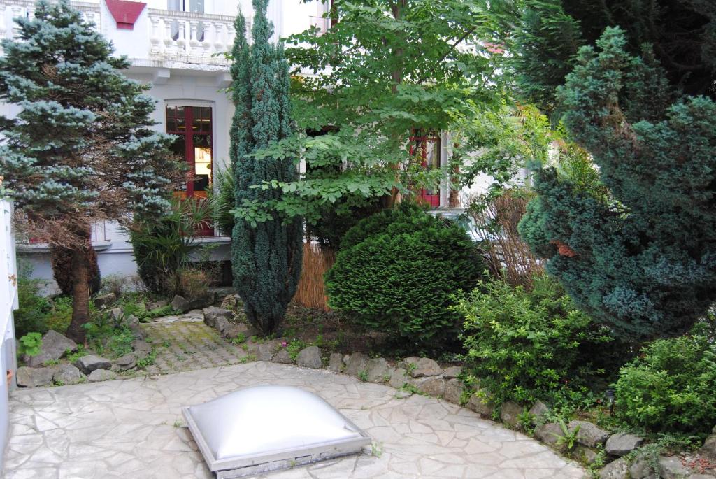 a garden with a mattress in front of a house at Hôtel Myosotis in Lourdes