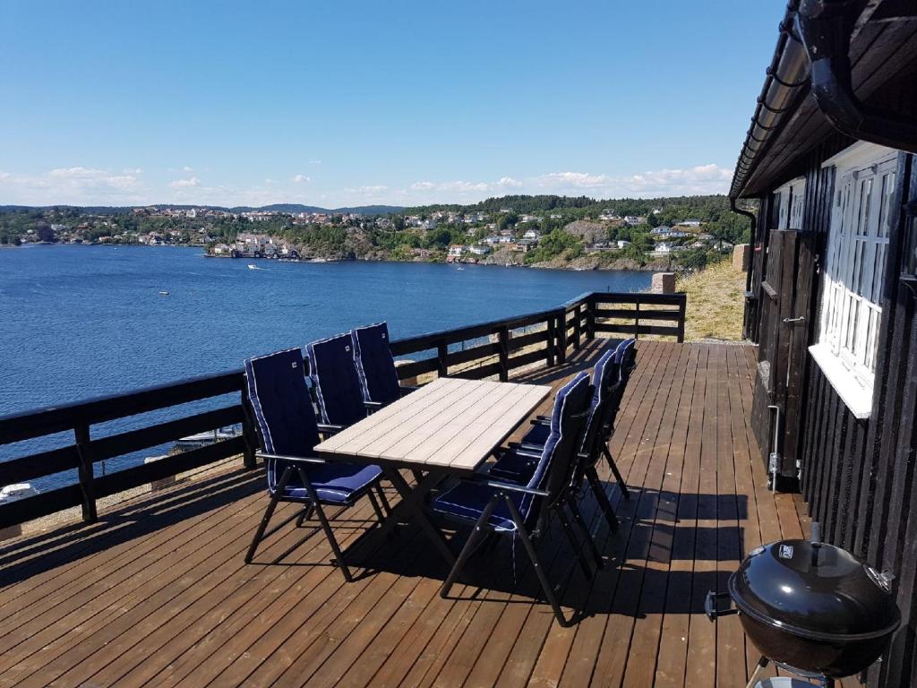 un tavolo e sedie su una terrazza con vista sull'acqua di Vesterveien Panorama ad Arendal