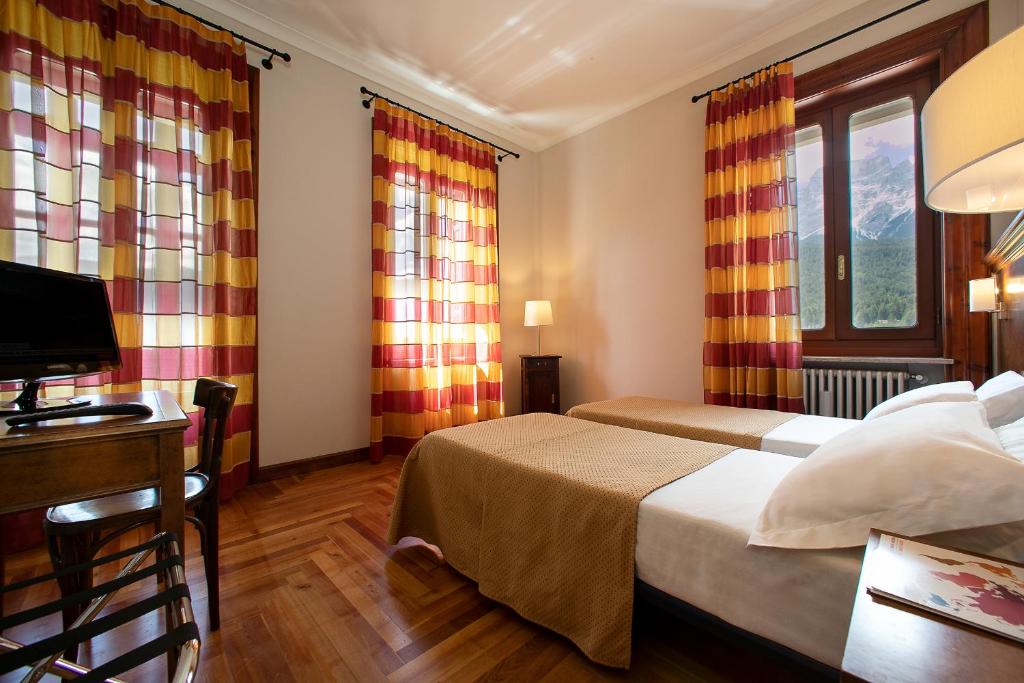 Postel nebo postele na pokoji v ubytování TH Borca di Cadore - Park Hotel Des Dolomites