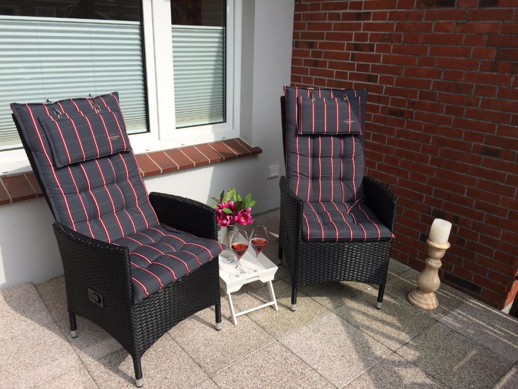 2 Stühle und ein Tisch auf der Terrasse in der Unterkunft „Lüttje Nüst“ in Emden