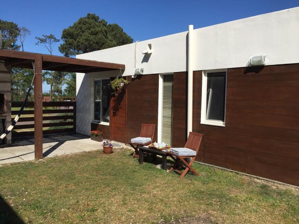 ein Haus mit einem Tisch und Stühlen im Hof in der Unterkunft Descanso en Piriápolis in Piriápolis