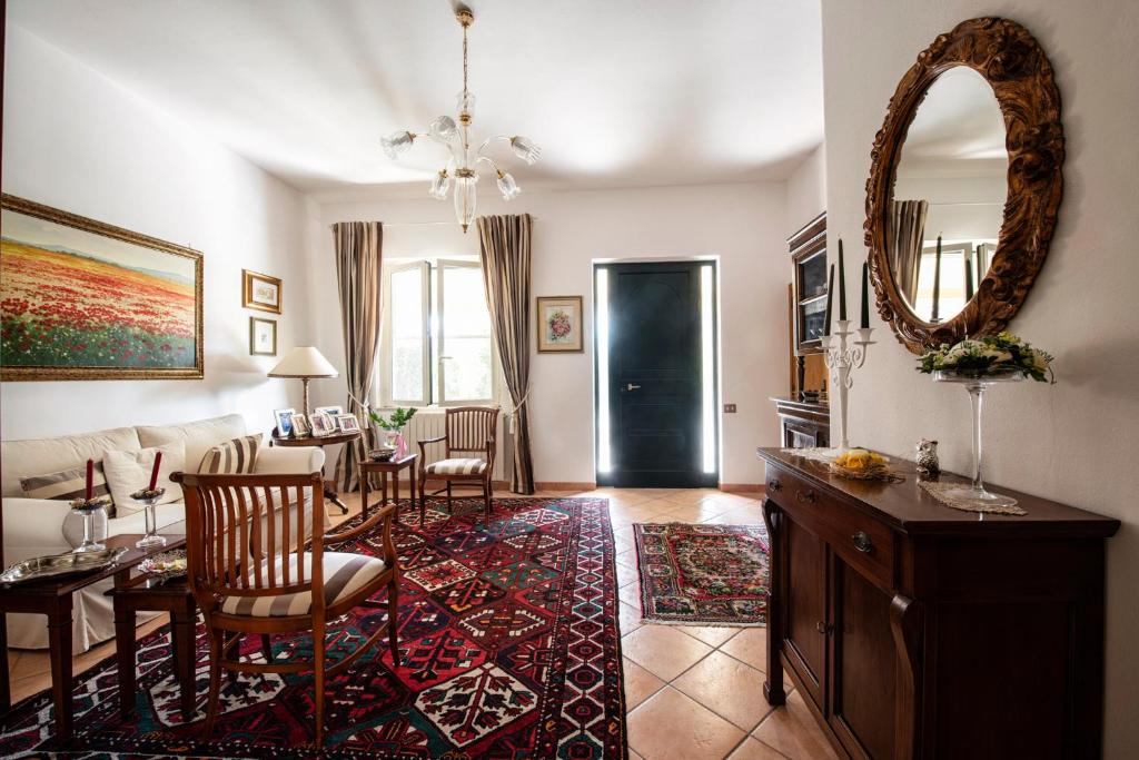 ein Wohnzimmer mit einem Tisch, Stühlen und einem Spiegel in der Unterkunft B&B Da Marcella in Oristano