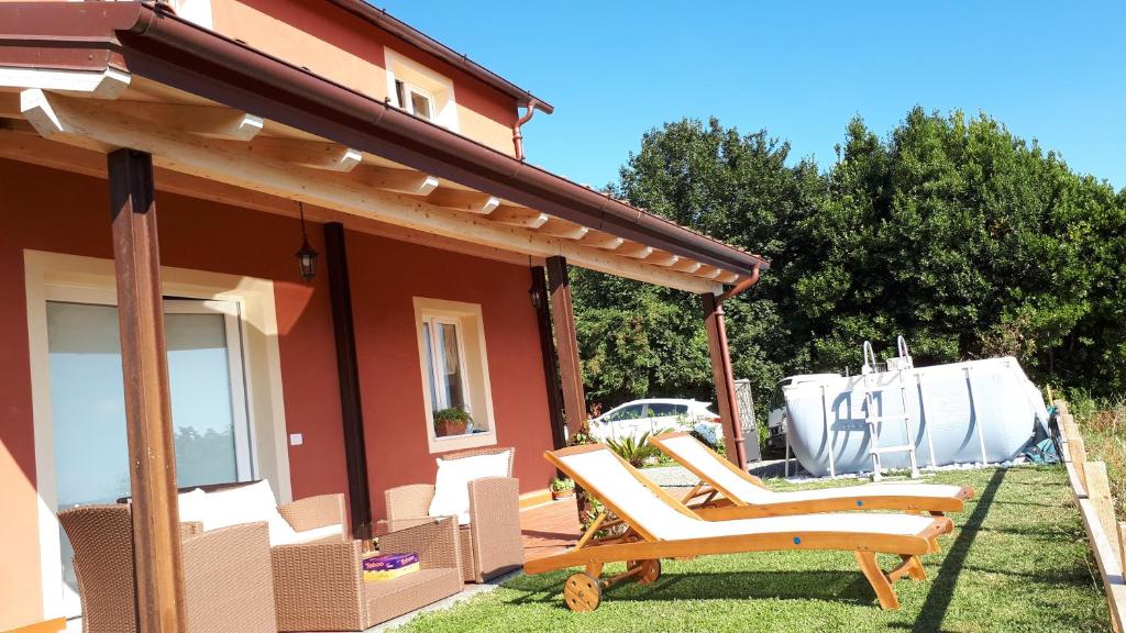 ein paar Stühle auf dem Vorgarten eines Hauses in der Unterkunft Casa Vacanza Alba in Sarzana