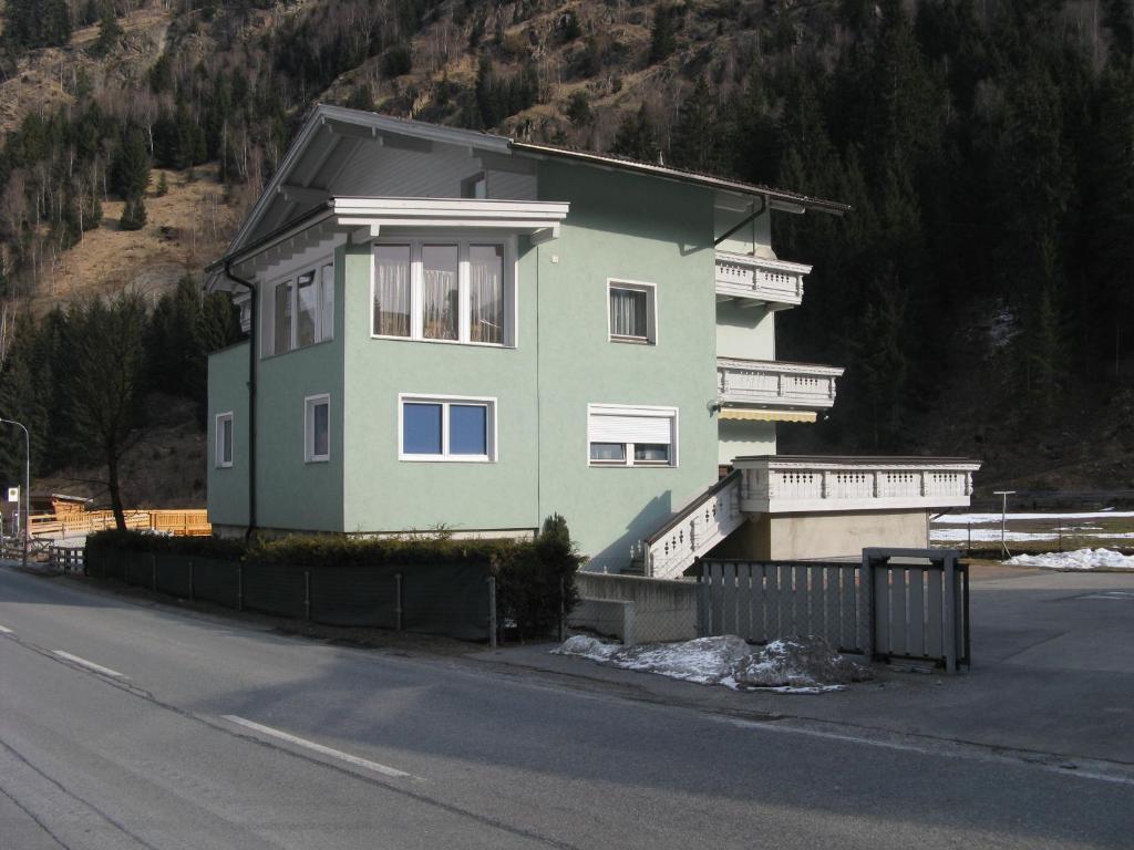 a green house on the side of a road at Ferienwohnung Wohlfarter in Jerzens