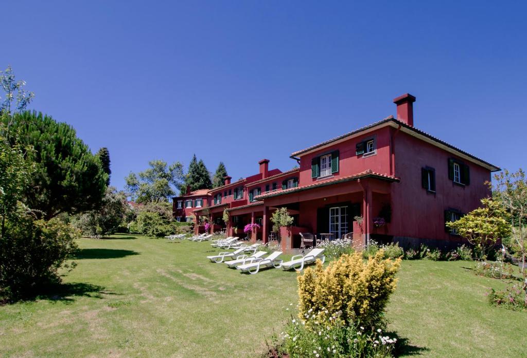 een rij witte stoelen voor een gebouw bij Quinta Santo Antonio Da Serra in Santa Cruz