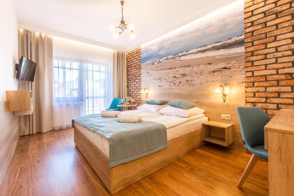 sypialnia z łóżkiem i ceglaną ścianą w obiekcie Słoneczny Dwór w mieście Krynica Morska