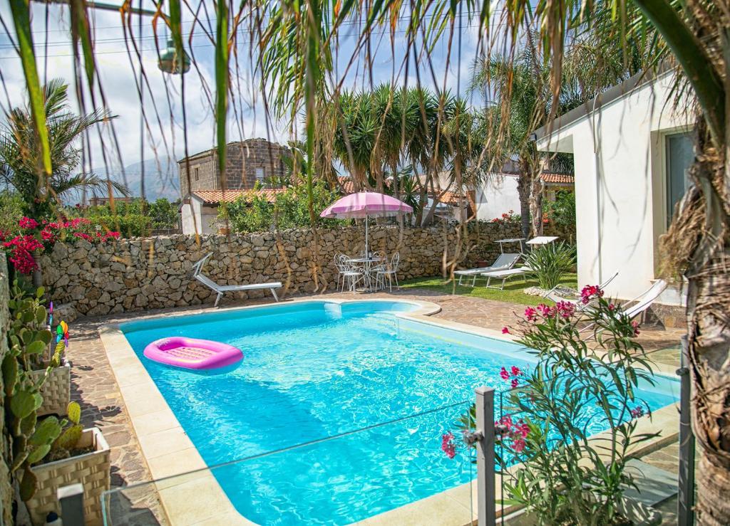 una piscina con un frisbee rosa. en Villa Manzella piscina privata en Cinisi