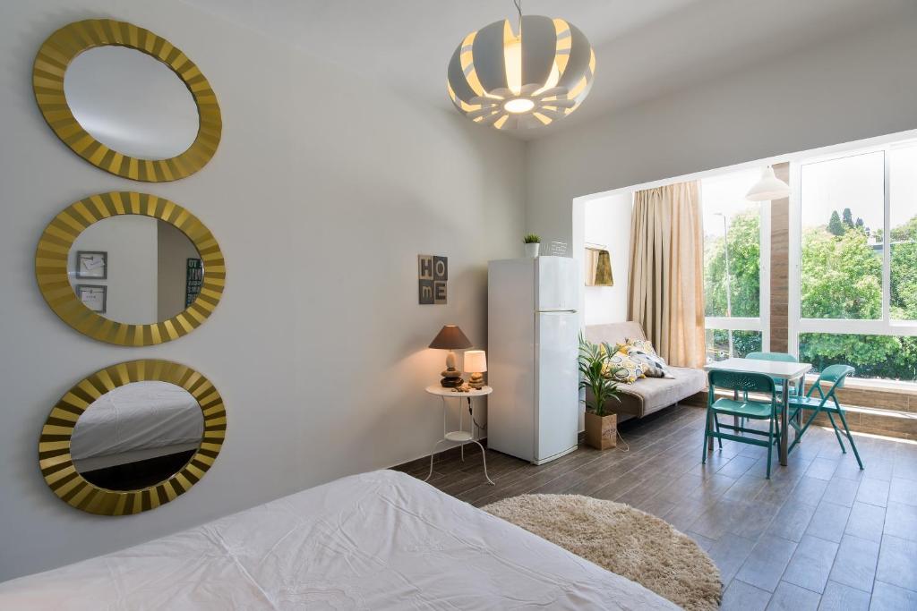 a bedroom with mirrors on the wall and a living room at Eshkol Housing Haifa - Moriya Suites Boutique Complex in Haifa