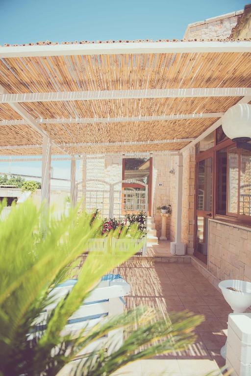 an outdoor patio with a wooden ceiling and plants at Hotel San Giovanni in Polignano a Mare