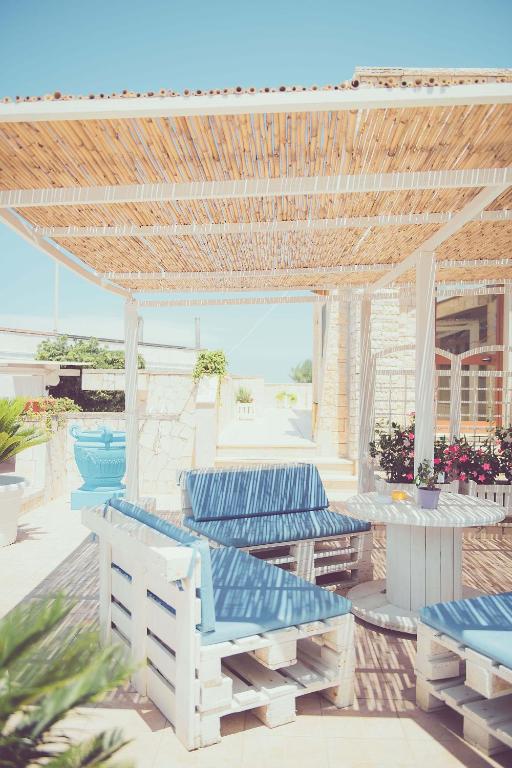 a patio with blue chairs and tables on a beach at Hotel San Giovanni in Polignano a Mare
