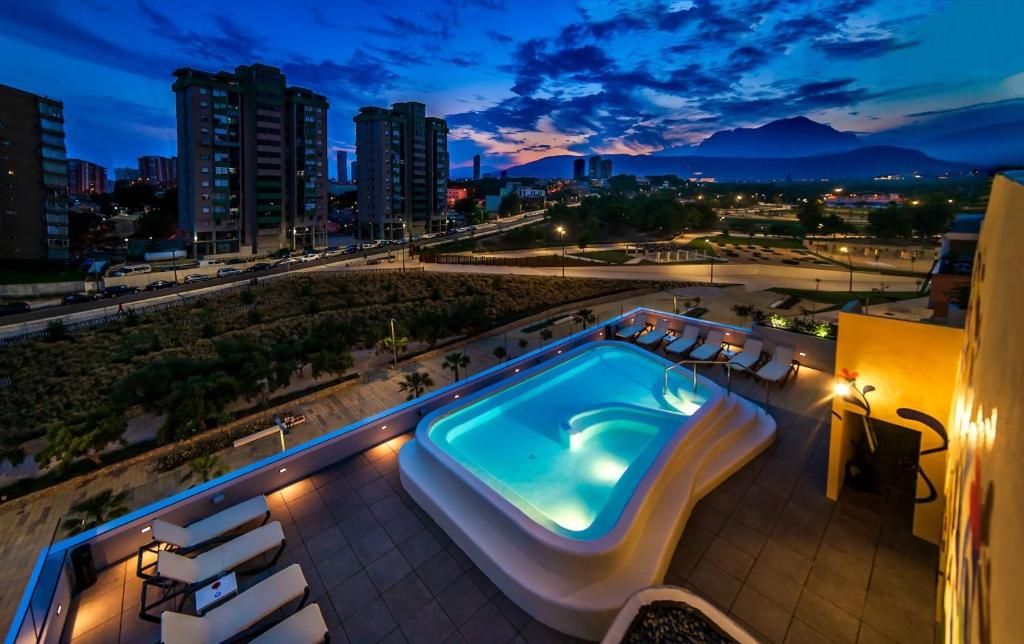 a swimming pool on top of a building at night at Hotel Carlos I in Benidorm