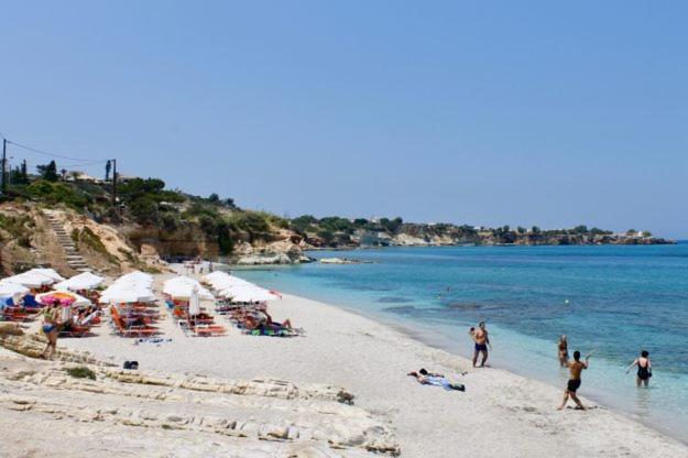 un gruppo di persone su una spiaggia con ombrelloni di Villa Saradari a Hersonissos