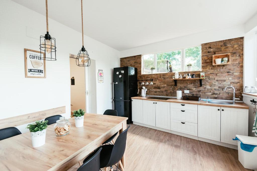 a kitchen with a wooden table and a brick wall at Riverside Pool Villa in Novi Sad