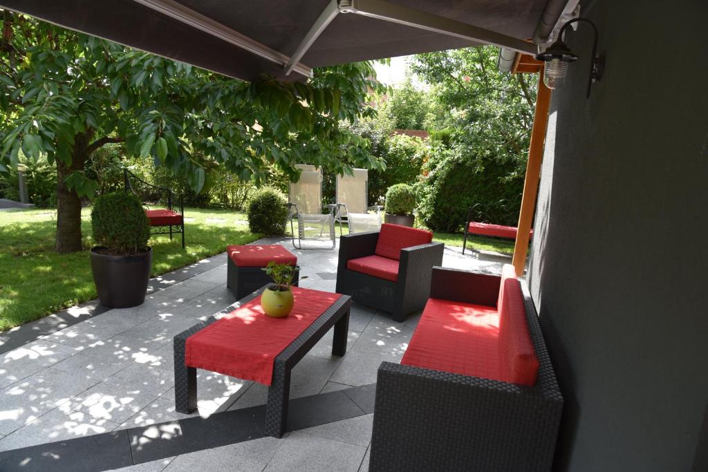 eine Terrasse mit Sofas, Stühlen und einem Tisch in der Unterkunft Le cerisier in Kaysersberg