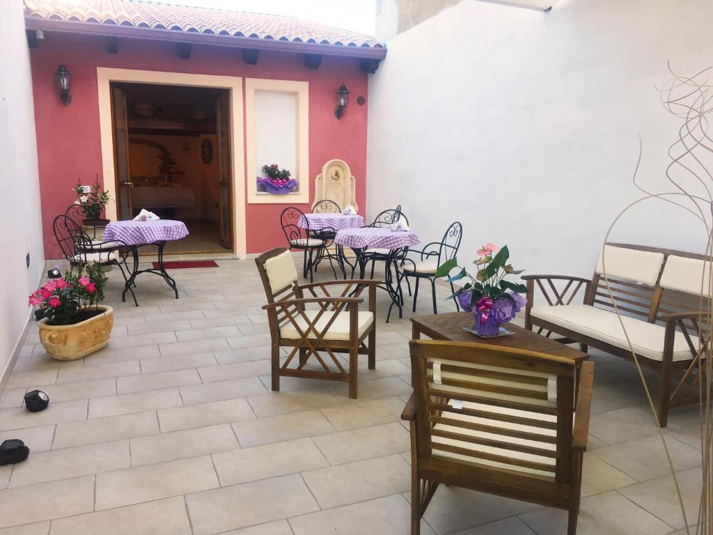 a patio with a bunch of tables and chairs at B&B Mariposa in Sennori