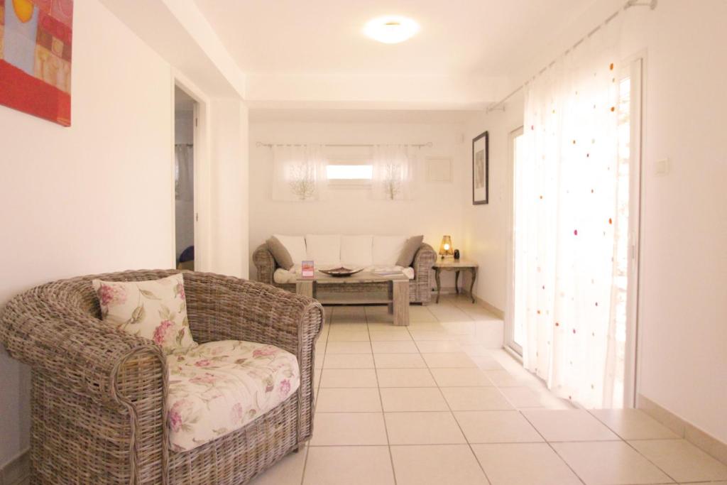 a living room with a chair and a couch at Villa Ghiatone in Pietrosella