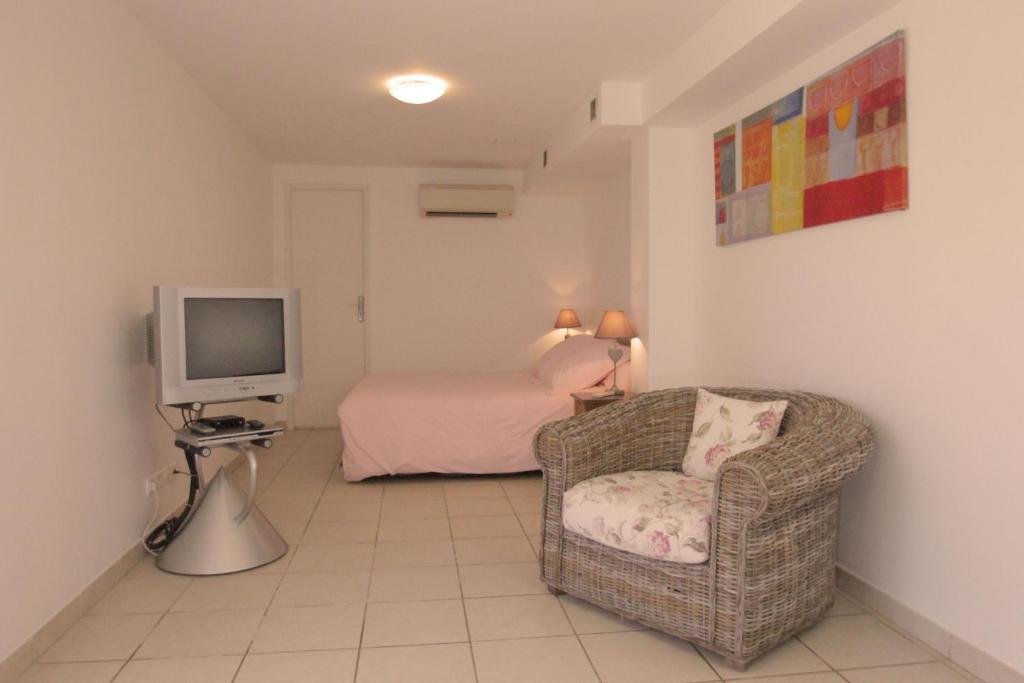 a living room with a chair and a television at Villa Ghiatone in Pietrosella