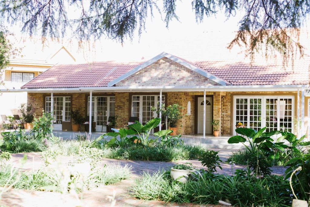 dom z ogrodem przed nim w obiekcie A Country Garden Guest House w mieście Potchefstroom