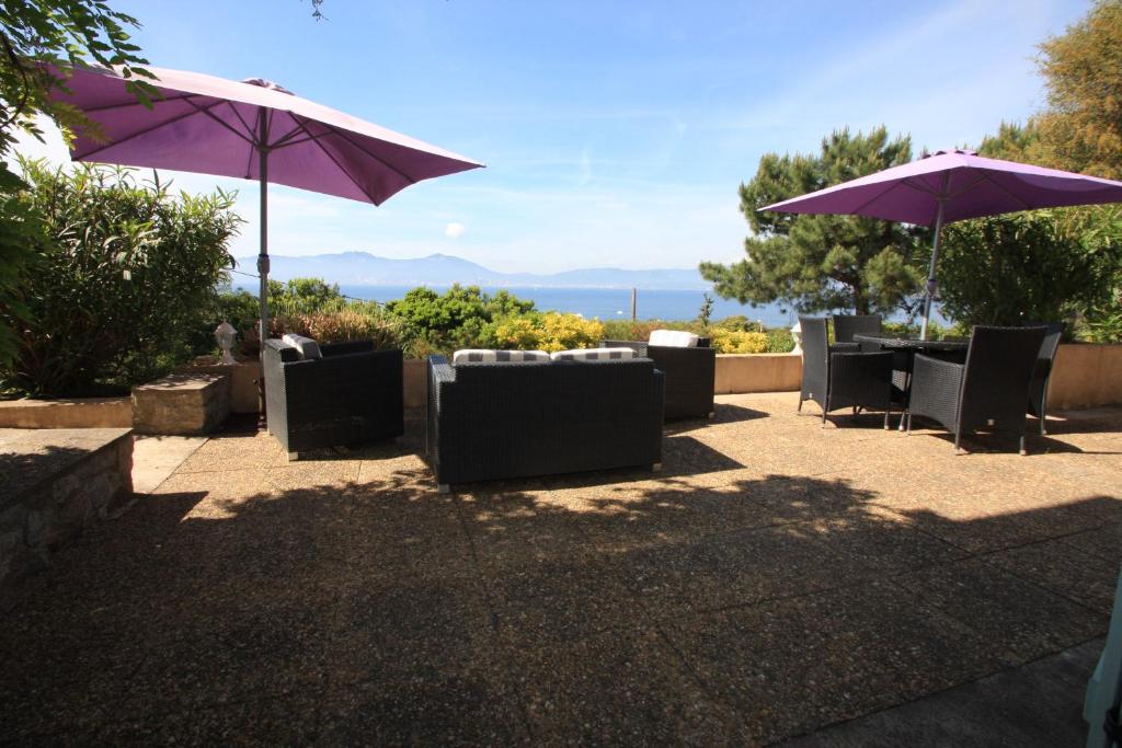 a patio with tables and chairs and umbrellas at Villa Ghiatone in Pietrosella
