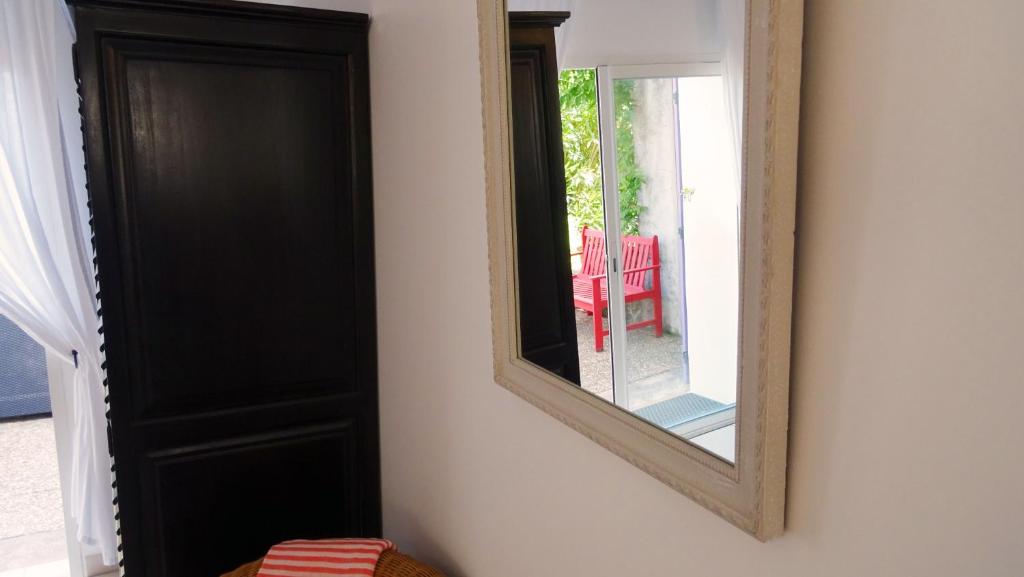 a mirror hanging on a wall next to a door at Villa Ghiatone in Pietrosella
