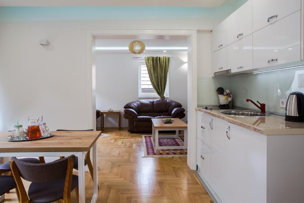 a kitchen and living room with a table and a couch at Guest House Hendek in Sarajevo