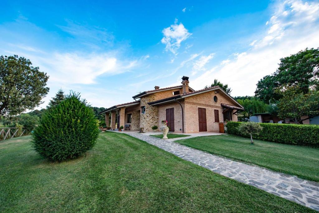 une maison avec une allée en pierre et une cour herbeuse dans l'établissement B&B Madonna Carradori, à Offagna