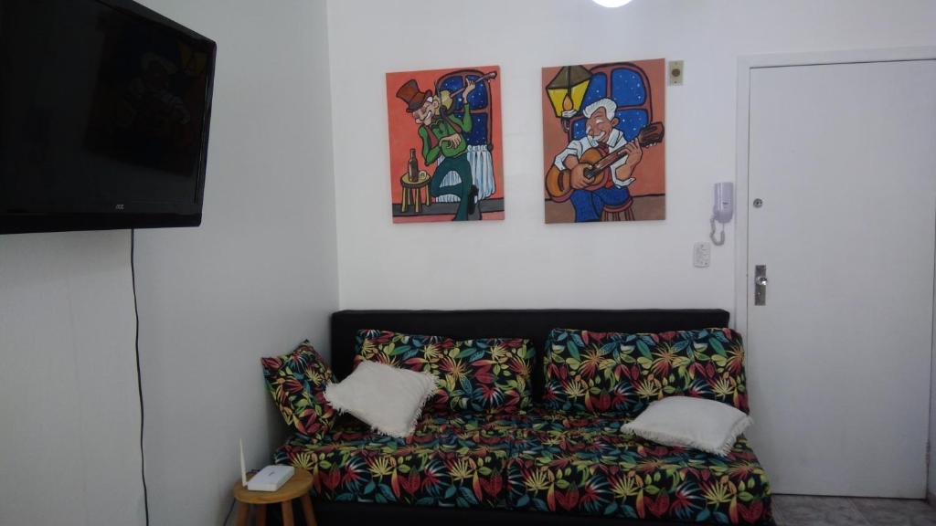 un sofá en una habitación con pinturas en la pared en Apto bem localizado, en Balneário Camboriú