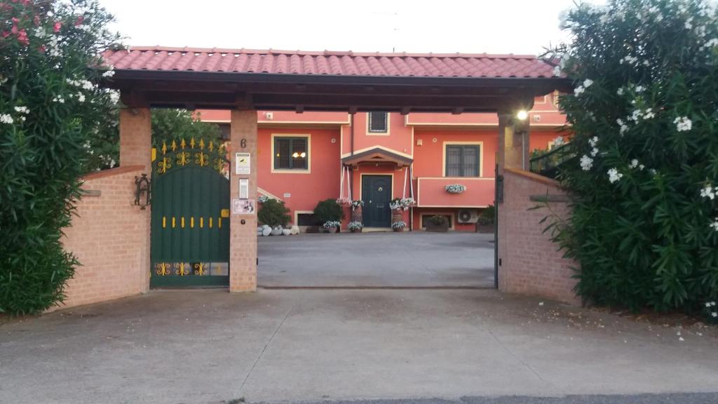 una casa naranja con una puerta verde y un camino de entrada en Le Palme Bed And Breakfast en Briatico