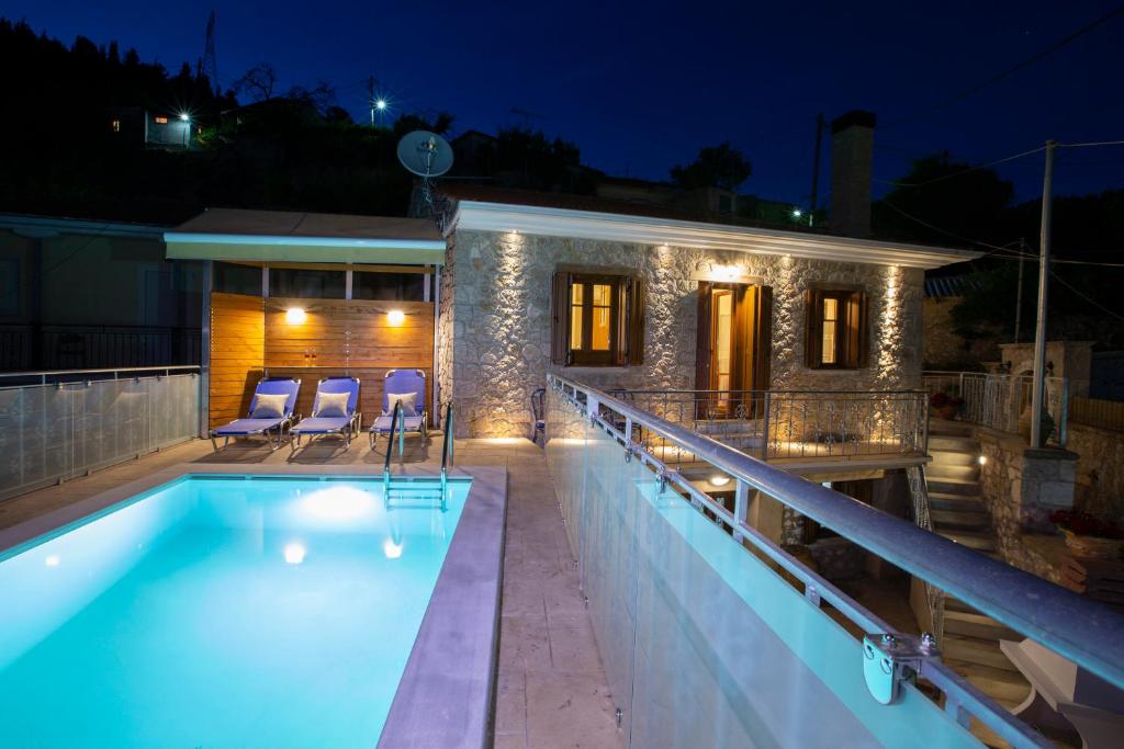 una casa con piscina por la noche en Villa Eglouvi, en Englouví
