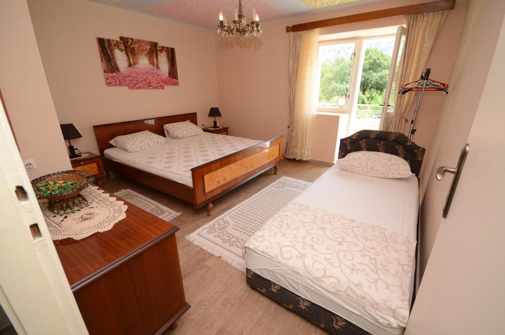 sypialnia z 2 łóżkami i oknem w obiekcie Stone House Dragutinovic w Kotorze