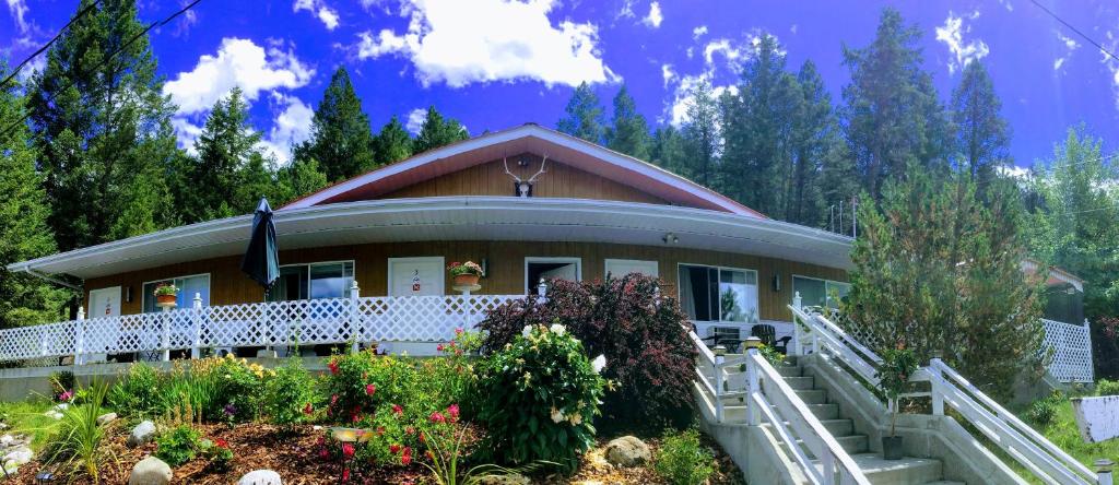 a house with a porch and flowers in front of it at Crescent Motel in Radium Hot Springs