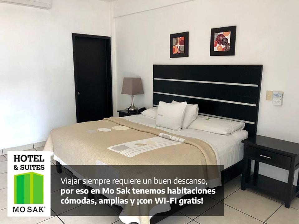 a hotel room with a bed and a desk at Hotel & Suites Mo Sak in Tapachula