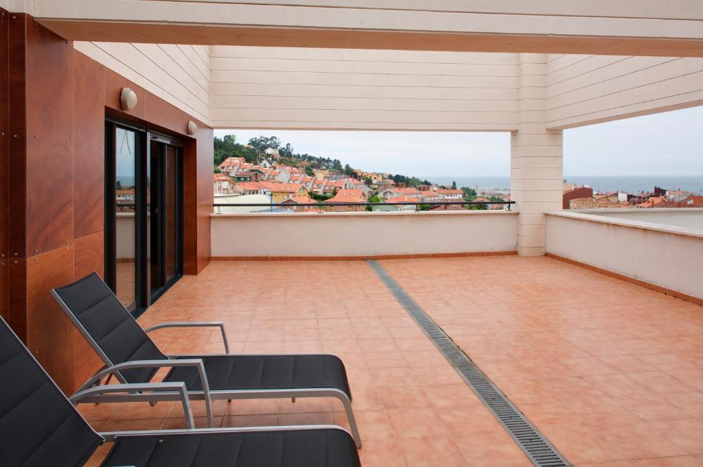 balcón con sillas y vistas a la ciudad en Ático con amplia terraza Nautilus I, en Luanco