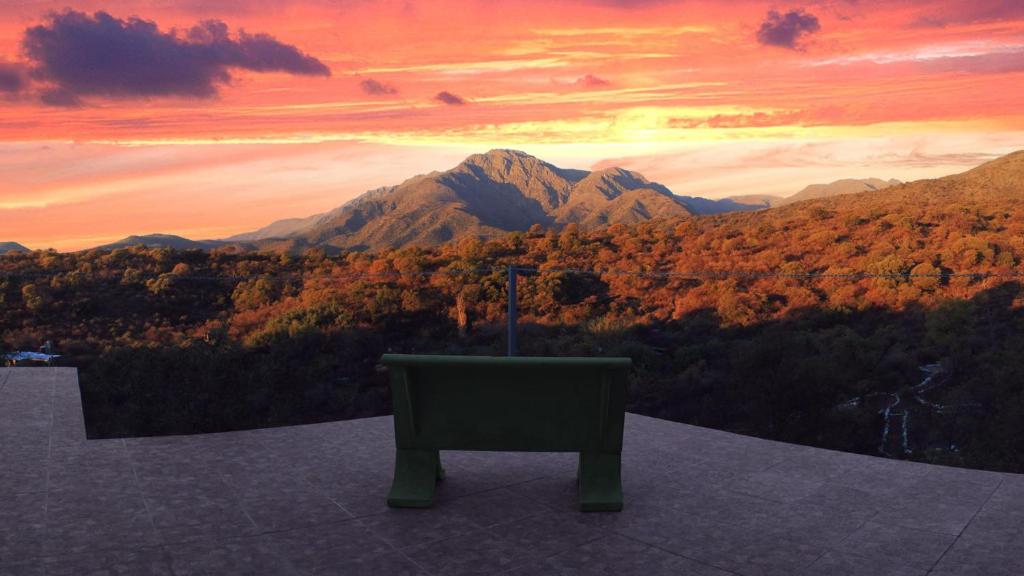 una silla sentada en una cornisa con vistas a una montaña en Espacio Zen Deros en Capilla del Monte