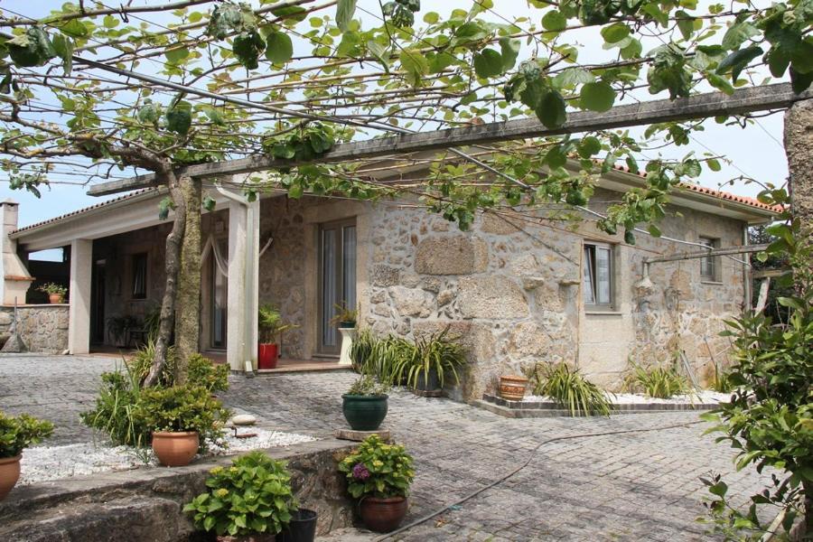 una casa de piedra con macetas delante de ella en 'Casa do Afonso', en Esposende