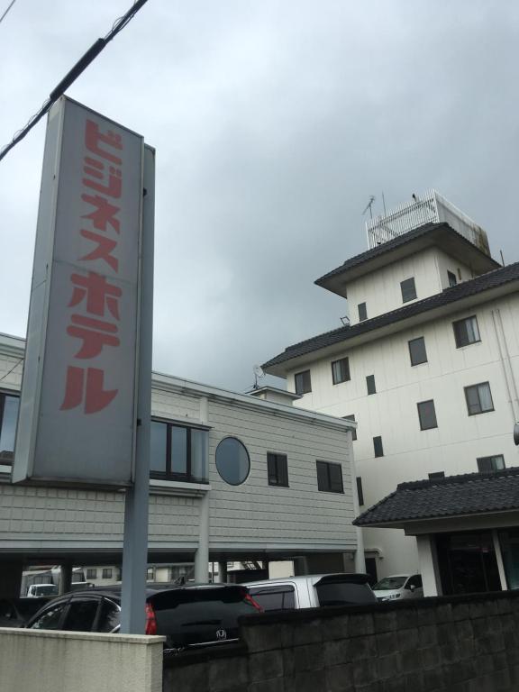 un cartel en un estacionamiento frente a un edificio en Business Hotel Ishimura, en Mibu