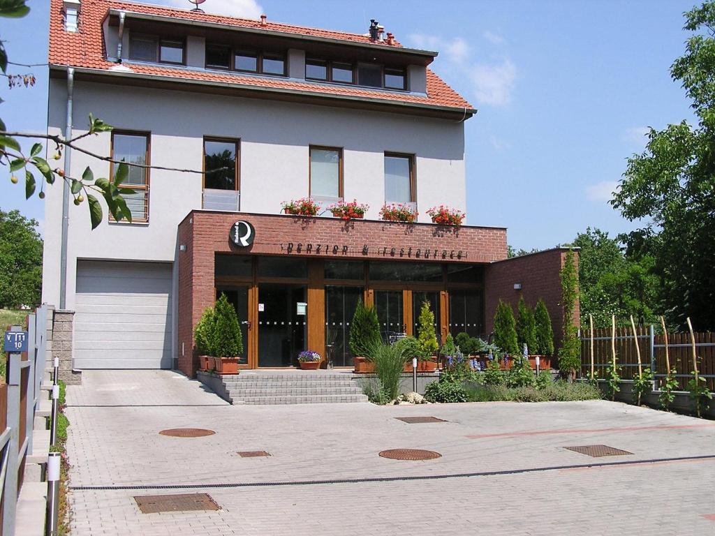 un edificio con un montón de plantas delante de él en Penzion Ruland, en Brno
