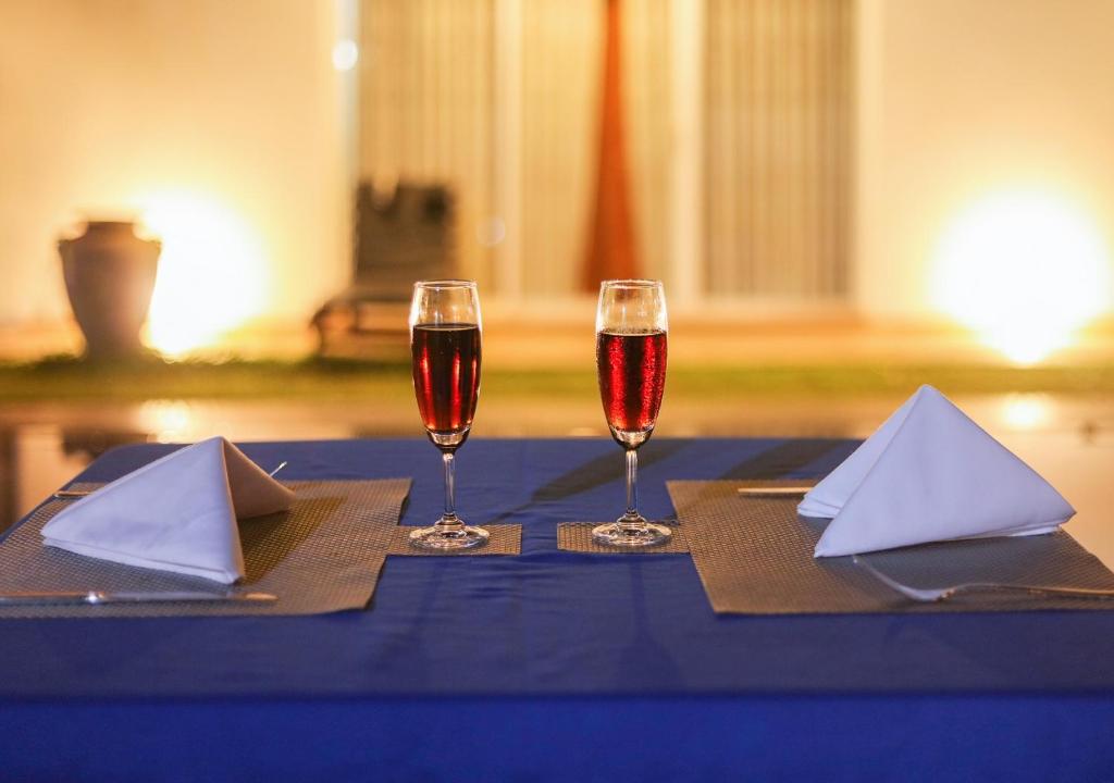deux verres de vin assis sur une table bleue dans l'établissement White Rose Beach Resort, à Marawila