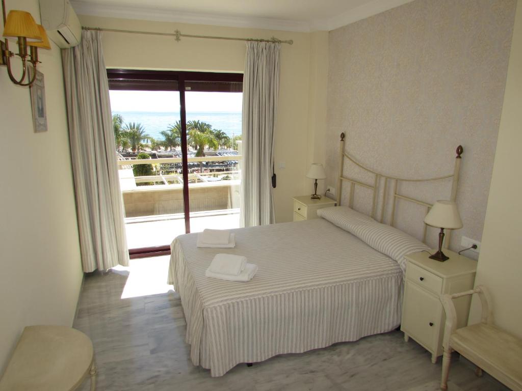 a bedroom with a bed and a view of the ocean at Home4Holidays in Nerja