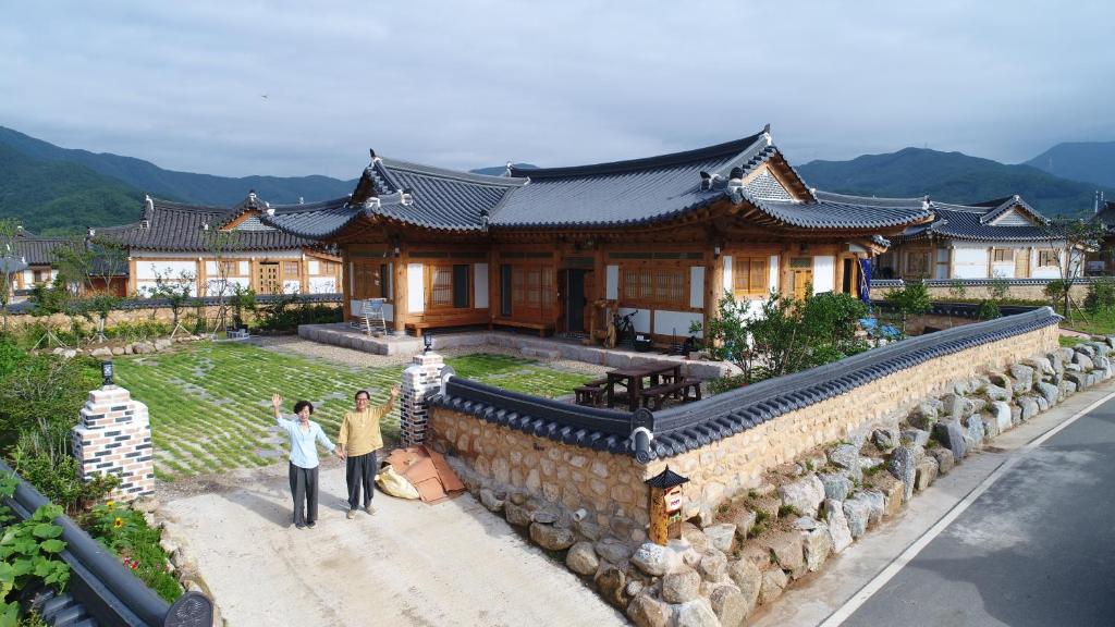 zwei Menschen, die vor einem Haus laufen in der Unterkunft Mirinae Hanok Tradiational House in Gwangyang