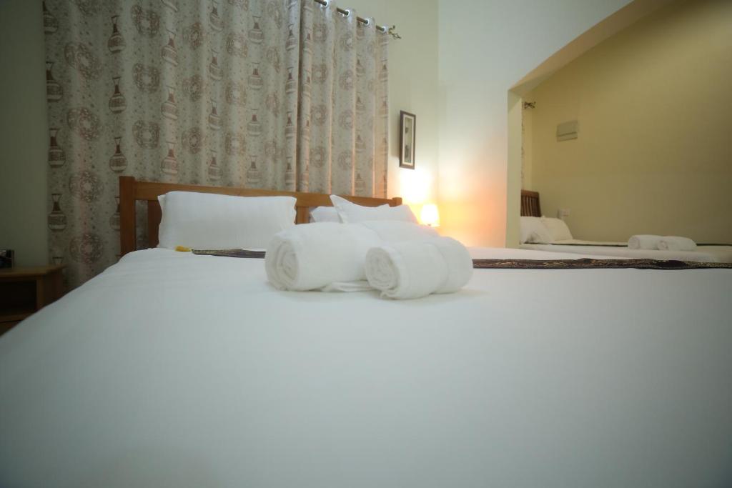 Postel nebo postele na pokoji v ubytování Entebbe Palm Hotel