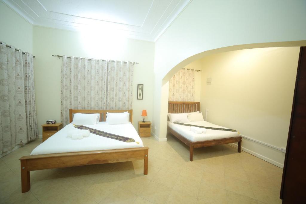 Postel nebo postele na pokoji v ubytování Entebbe Palm Hotel