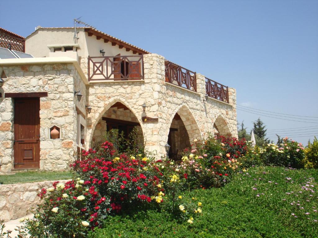 Villa for rent in MILIOU close to Lachi & Peyia في ميليو: بيت حجري فيه ورد