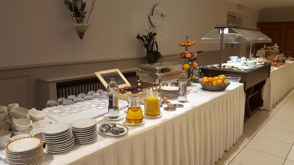 a long table with plates and cups and food on it at Hotel Re'ser Stuff in Roeser