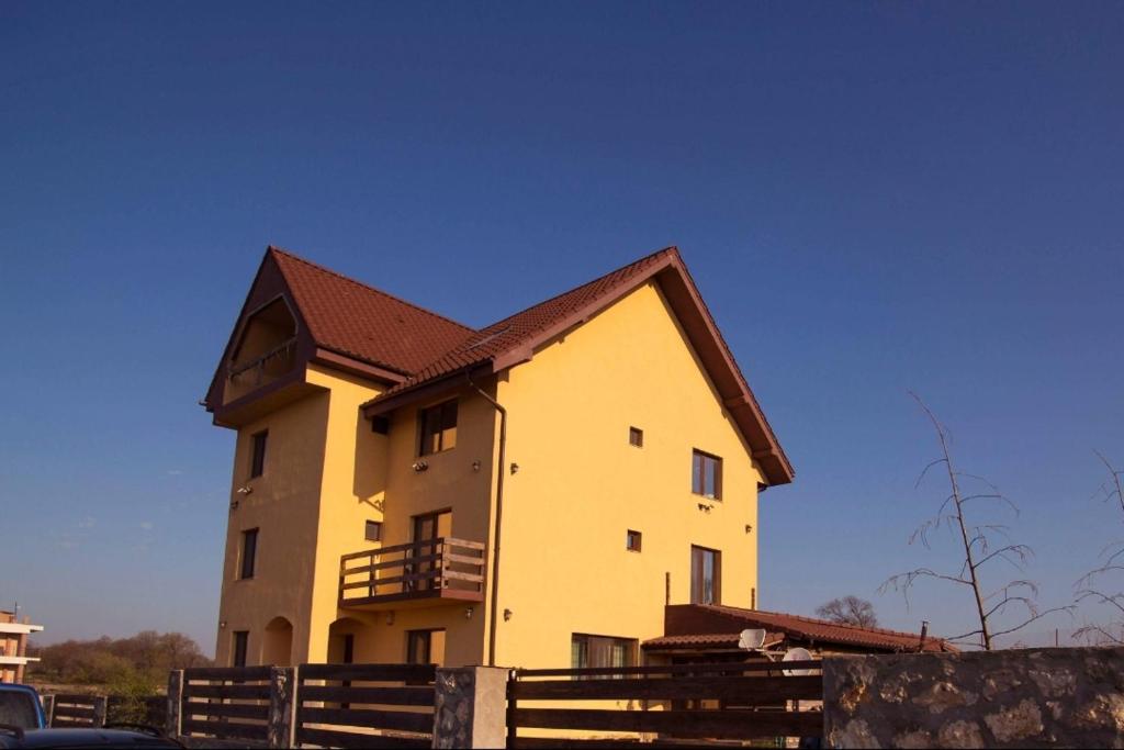 a large yellow building with a brown roof at Vila Victor - Adults only in Techirghiol